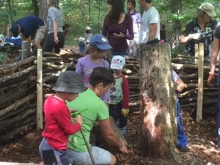 Eltern und Kinder bauen gemeinsam einen Flechtzaun