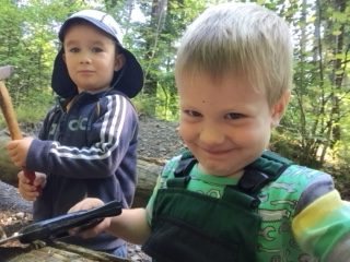 Zwei Kinder sägen an einem Baumstamm