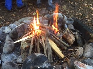 Flammen schlagen aus der Feuerstelle aus Steinen