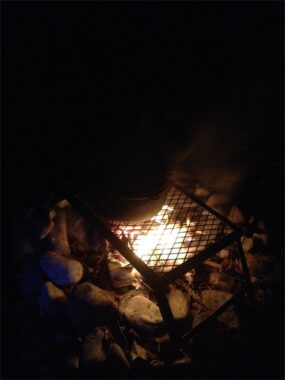 Glut und Flammen in der Feuerschale bei Dunkelheit