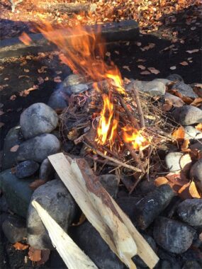 Ein Feuer brennt in einer Feuerstelle aus Steinen