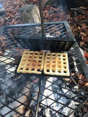 Waffeln backen im Waffeleisen über der Feuerstelle